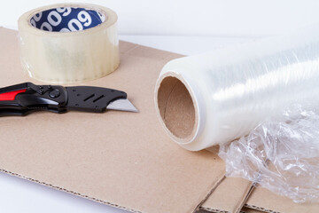 Packing the goods in a cardboard box and stretch film. Tools for packing parcels at the post...