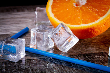 Orange with a straw for cocktails. Ice orange. Juice with ice.Orange drink. Copyspace.