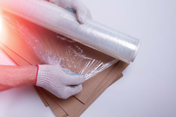 Packaging material. Stretch film and cardboard packaging on a white background. Packing the goods before shipping..