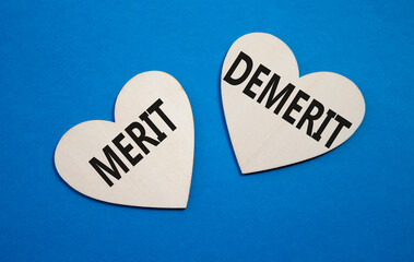 Merit or Demerit symbol. Concept word Merit or Demerit on wooden hearts. Beautiful blue background....