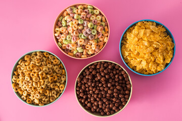 Assorted cereal bowls on pink background for breakfast 