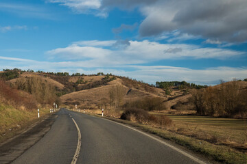 Curved road leading through dry hills
