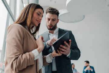 Business colleagues using digital tablet in modern office