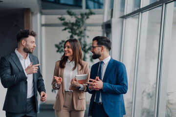 Businesspeople walking and talking in modern office building