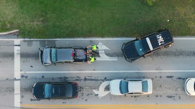 Car crash with first responders helping at accident site on American street. Vehicle collision on road in USA.