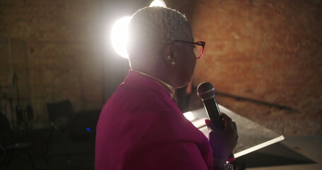 Pastor leading service in church, congregation in spiritual worship with hands raised, focus on...