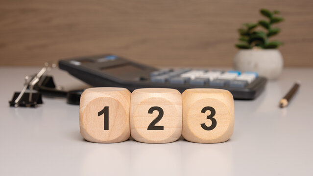 Wooden blocks with numbers 1, 2, and 3 on office desk