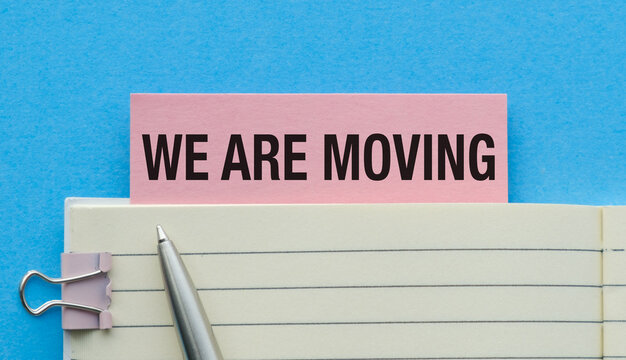 A pink sticky note with the words We are Moving written on it - Powered by Adobe