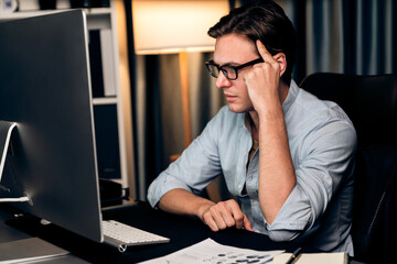 Thinking of stressful financial analyst researching on business paragraph on pc screen with dynamic...