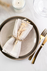 Elegant minimal table setting with wheat decoration in neutral tones