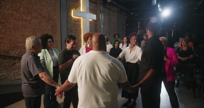 Group of people holding hands in prayer during church service, pastor leading spiritual moment, community united in faith and prayer, evangelical Christian worship
