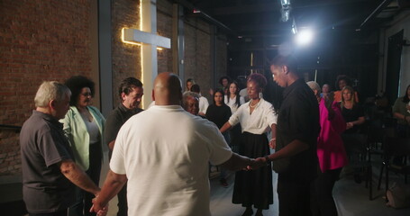 Group of people holding hands in prayer during church service, pastor leading spiritual moment, community united in faith and prayer, evangelical Christian worship