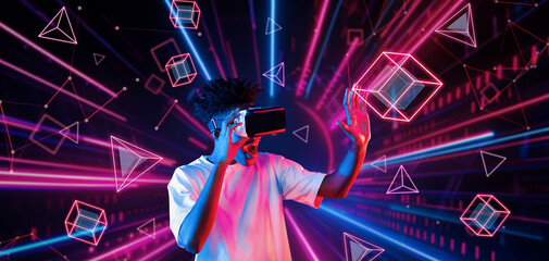 Smart teenager wearing VR glasses and excited about geometric shape. African gamer wearing casual...