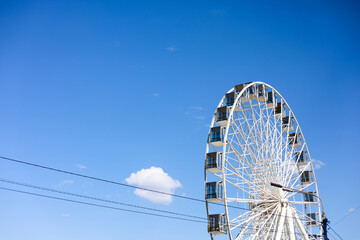 Ferris wheel under clear blue sky at local amusement park on sunny afternoon