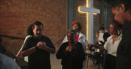 Close-up of congregation in prayer, hands held in spiritual connection, leader guiding worship in modern evangelical church setting, community united in faith