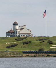 white building on green meadow grass hill next to american flag of the united states of america usa...