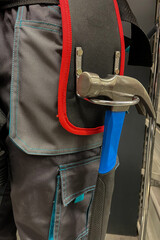 Close-up of tool belt and a hammer on a male construction worker. The concept of repair and construction