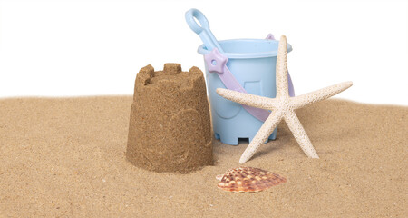 Seau de plage, jeux et coquillages sur un fond de sable de plage
