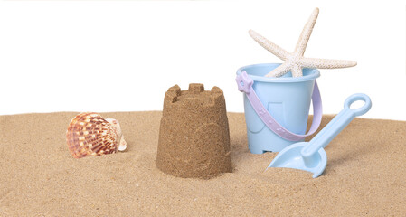 Seau de plage, jeux et coquillages sur un fond de sable de plage