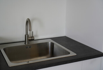 Stainless steel kitchen sink in a clean, modern interior.