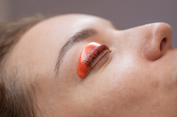 Caucasian woman undergoing eyelash lamination procedure. 