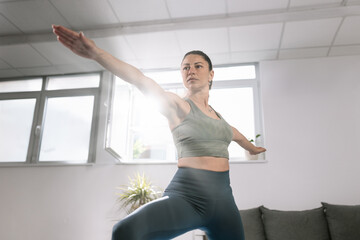 Yoga practice indoors with natural light shining through the windows in a serene environment