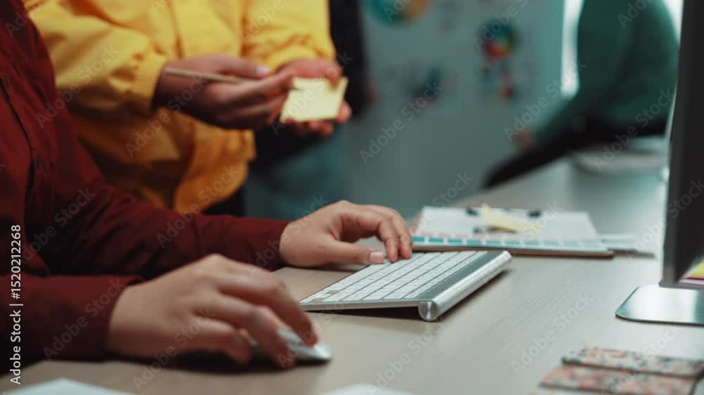 Poster a focused individual types on a keyboard, while another person assists, showcasing technology use in