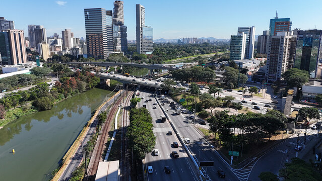 Vis&atilde;o a&eacute;rea da Marginal Pinheiros, uma das principais vias de S&atilde;o Paulo, com pr&eacute;dios modernos, &aacute;reas comerciais e o rio Pinheiros cortando a paisagem urbana paulistana