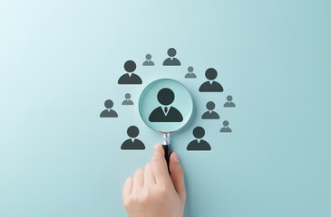 Talent Search and Recruitment Concept. Hand holding magnifying glass over candidate icons,...