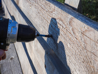 close-up of a screwdriver screwing a screw into wood