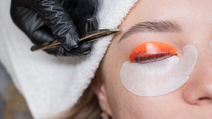 Caucasian woman undergoing eyelash lamination procedure. 