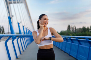 Fit lady in sportswear preparing for workout, female jogger listening music during training...