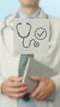 Medical professional wearing white coat, holding stethoscope icon on sticky note, representing quality patient care within clinical hospital setting