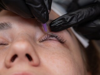 The process of professional eyelash lamination in a salon. 