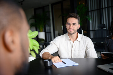 Professional In White Shirt And Glasses Conducts Business Meeting In Modern Office With Natural...