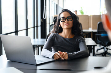 Confident Young Asian Woman in Modern Office with Bright Natural Lighting