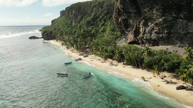 Drone view showcasing Playa Front&oacute;n&rsquo;s natural contrast &mdash; jagged cliffs rising over calm turquoise water, framed by untouched vegetation
