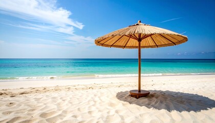 An empty, clean sandy beach with soft waves, smooth driftwood, and a straw parasol casting a shadow. 