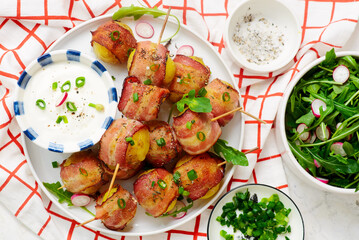 Bacon wrapped potato kebobs with sour cream.top veiw.selective focus