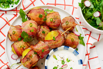 Bacon wrapped potato kebobs with sour cream.top veiw.selective focus