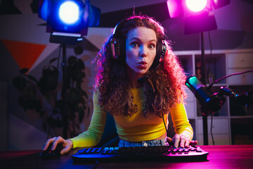 Charming girl livestreaming video games at home with neon lighting creating a vibrant atmosphere of...