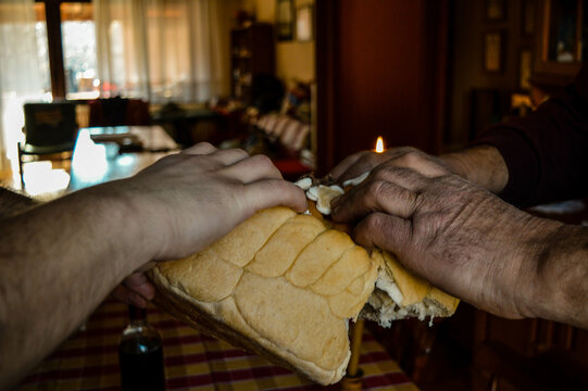 Father and son ceremonially tearing the Slava bread as part of the traditional Serbian Orthodox patron saint celebration