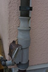 An intriguing outdoor pipe system with a focus on its functional details and weathered charm, set against a muted, earthy palette.