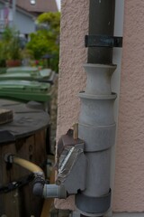 An intriguing outdoor pipe system with a focus on its functional details and weathered charm, set against a muted, earthy palette.