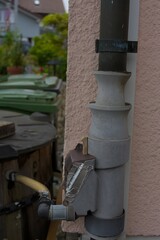 An intriguing outdoor pipe system with a focus on its functional details and weathered charm, set against a muted, earthy palette.