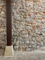 A support beam near an old stone wall structure - a  element of half-timbered architecture.