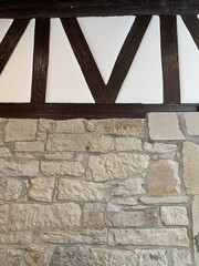 Stone wall with black timber frame, a classic element of half-timbered architecture. 