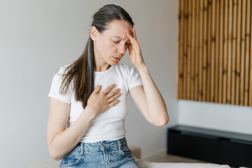 Woman experiencing symptoms of chronic illness in a home living space