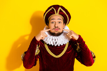 A young man dressed as a nobleman poses humorously against a vibrant yellow background