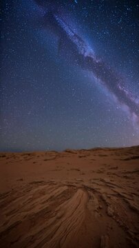 Time Lapse of Starry Night Sky and Milky Way Over Desert Landscape with Rocks and Sand, Stars Moving Across Wide Open Sky, Ideal for Nature and Astronomy Backgrounds